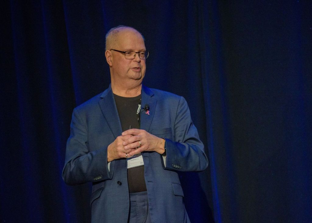 Mike Martineau on stage speaking at a health informatics conference